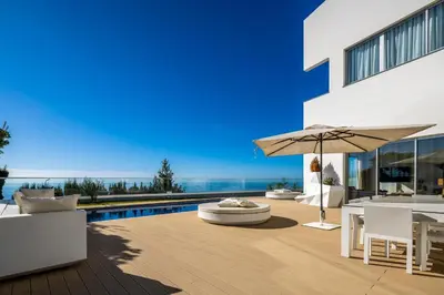 a patio with an umbrella and a swimming pool at Villa Carlota by Holiday Rental Madeira in Caniço
