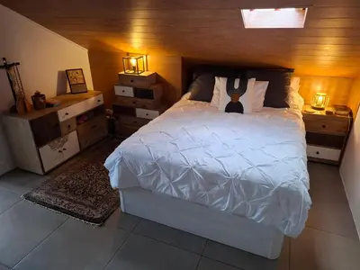 a bedroom with a white bed and two night stands at Sally's Loft - Penthouse - Honeymoon suite in Ponta do Sol