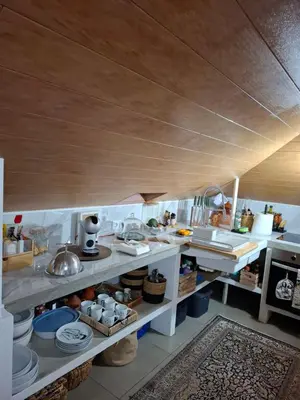 a large kitchen with white counters and a wooden ceiling at Sally's Loft - Penthouse - Honeymoon suite in Ponta do Sol