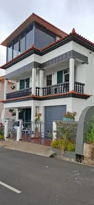 a large white house on the side of a street at Sally's Loft - Penthouse - Honeymoon suite in Ponta do Sol