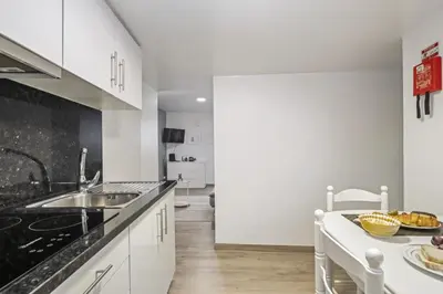 a kitchen with white cabinets and a sink at Seaside Charm I in Câmara de Lobos