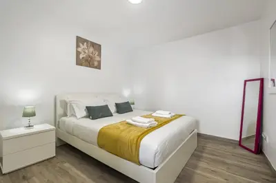 a white bedroom with a bed and a mirror at Seaside Charm I in Câmara de Lobos
