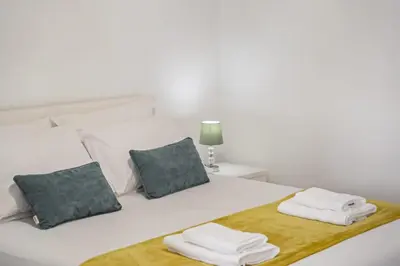 a white bed with two folded towels on it at Seaside Charm I in Câmara de Lobos