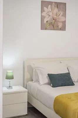 a white bedroom with a white bed and a lamp at Seaside Charm I in Câmara de Lobos