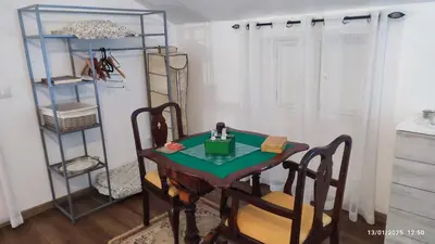 a table and chairs in a room with a shelf at Recanto das Florenças - Casa 3 in Arco da Calheta