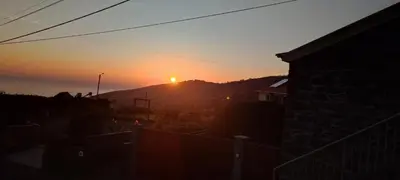 a sunset with the sun setting on a mountain at Recanto das Florenças - Casa 3 in Arco da Calheta