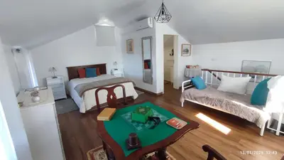 a bedroom with a bed and a table in a room at Recanto das Florenças - Casa 3 in Arco da Calheta
