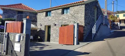 a stone house with an orange gate and a fence at Recanto das Florenças - Casa 3 in Arco da Calheta