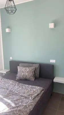 a bed in a bedroom with a blue wall at Modern house with private Pool in Sagres