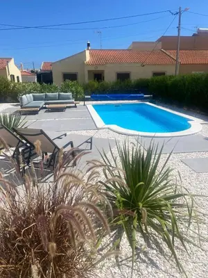 a swimming pool in a yard with chairs and plants at Modern house with private Pool in Sagres