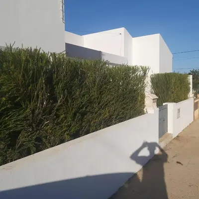 a shadow of a person standing next to a white wall at Modern house with private Pool in Sagres