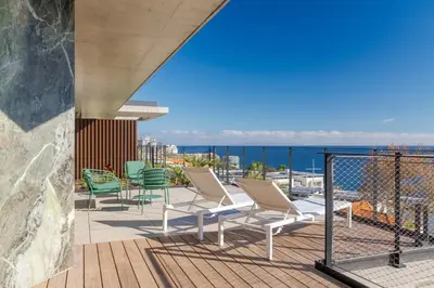 a deck with chairs and a view of the ocean at RJS Savoy Monumentalis by Holiday Rental Madeira in Funchal