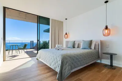 a bedroom with a bed with a view of the ocean at RJS Savoy Monumentalis by Holiday Rental Madeira in Funchal