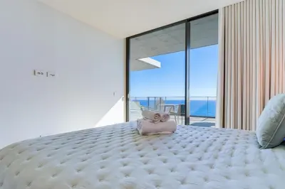 a white bed with a stuffed animal sitting on top of it at RJS Savoy Monumentalis by Holiday Rental Madeira in Funchal