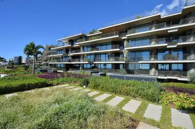 an apartment building with a garden in front of it at RJS Savoy Monumentalis by Holiday Rental Madeira in Funchal