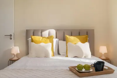 a bed with yellow pillows and a tray of green apples at Madeira Friendly Guest House by An Island Apart in Funchal