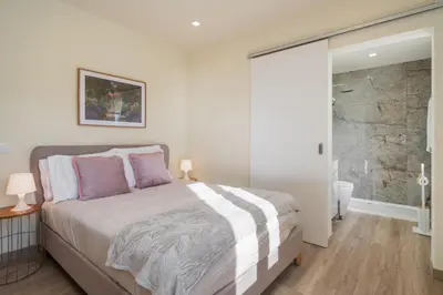 a bedroom with a large bed and a shower at Madeira Friendly Guest House by An Island Apart in Funchal