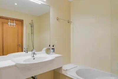 a bathroom with a sink and a toilet and a mirror at IVIS Home By Holiday Rental Madeira in Funchal