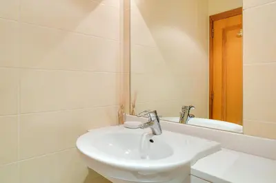 a white bathroom with a sink and a mirror at IVIS Home By Holiday Rental Madeira in Funchal