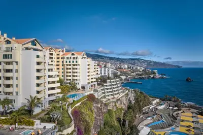 a group of buildings on a cliff next to the ocean at IVIS Home By Holiday Rental Madeira in Funchal
