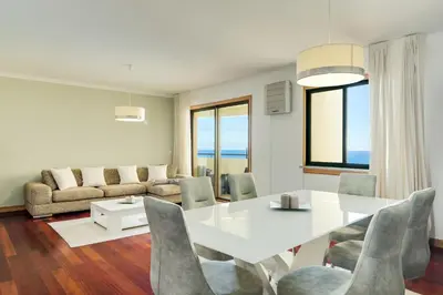 a living room with a white table and chairs at IVIS Home By Holiday Rental Madeira in Funchal