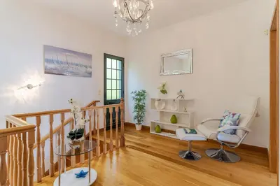 a living room with a staircase and a chandelier at Villa Black Rock by Holiday Rental Madeira in Santa Cruz