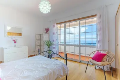 a bedroom with a bed and a large window at Villa Black Rock by Holiday Rental Madeira in Santa Cruz