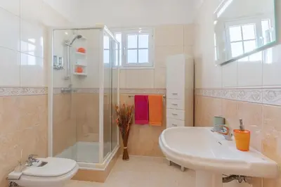 a bathroom with a sink and a shower and a toilet at Villa Black Rock by Holiday Rental Madeira in Santa Cruz