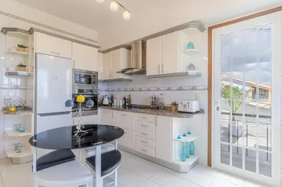 a kitchen with a table and a refrigerator at Villa Black Rock by Holiday Rental Madeira in Santa Cruz