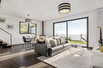 a living room with a couch and a table at Villa Soleil by Homie in Arco da Calheta