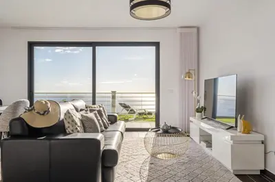 a living room with a couch and a large window at Villa Soleil by Homie in Arco da Calheta
