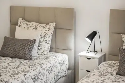 a bedroom with a bed and a lamp on a night stand at Villa Soleil by Homie in Arco da Calheta
