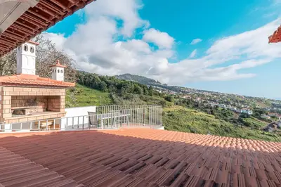 a view from the deck of a house with a clock tower at Vila Pitaias in Estreito da Calheta