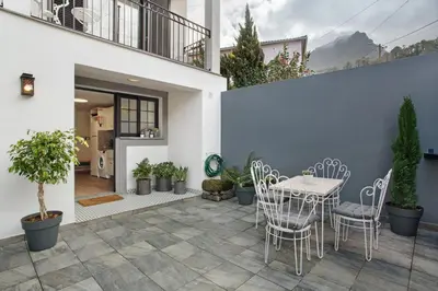 a patio with a table and chairs next to a building at Casa Francisco in São Vicente
