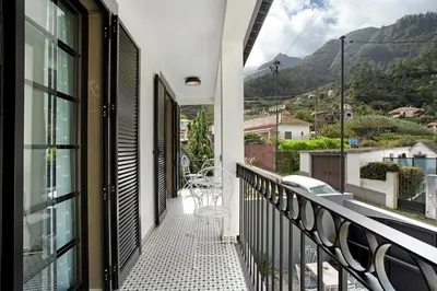 a patio with a table and chairs and a wall at Casa Francisco in São Vicente