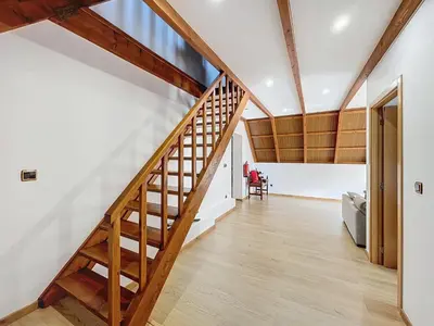 a wooden staircase in a living room with white walls at Casa do Avô in Santana
