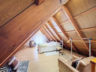 a attic room with a bed and a couch at Casa do Avô in Santana