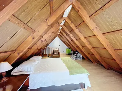 a bedroom with a large bed in a attic at Casa do Avô in Santana