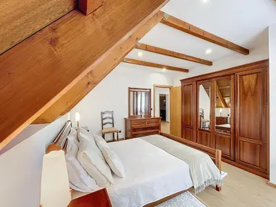 a bedroom with a white bed and wooden walls at Casa do Avô in Santana