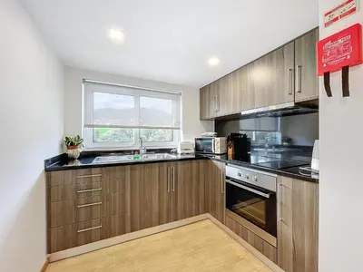 a kitchen with wooden cabinets and a window at Casa do Avô in Santana