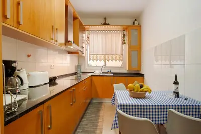a kitchen with a table with a bowl of fruit on it at Casa Orquidea T3 in Ponta do Sol