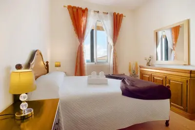 a bedroom with two beds and a window at Casa Orquidea T3 in Ponta do Sol