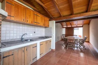 a kitchen with a sink and a table with chairs at Villa Pita in Relógio do Poiso