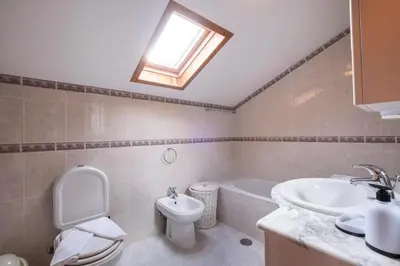 a bathroom with a toilet and a sink and a tub at Villa Pita in Relógio do Poiso