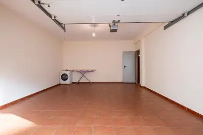 an empty room with a tiled floor and a television at Villa Pita in Relógio do Poiso