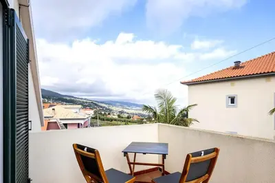 a table and chairs on a balcony with a view at Villa Pita in Relógio do Poiso