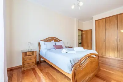 a bedroom with a wooden bed and a wooden dresser at Villa Pita in Relógio do Poiso