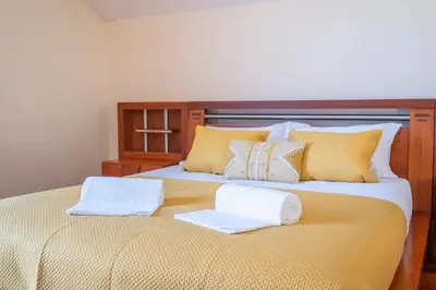 a bed with two white towels on top of it at Villa Pita in Relógio do Poiso