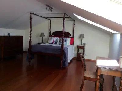 a bedroom with a canopy bed and a wooden floor at Excelente T3 Duplex Funchal in Funchal