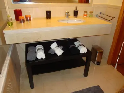a bathroom with a sink and a shelf under a counter at Excelente T3 Duplex Funchal in Funchal